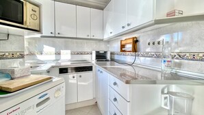 Eine Küche mit weißen Schränken, einer Mikrowelle, einem Toaster und einem Geschirrspüler.