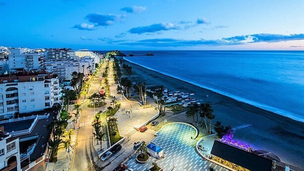A coastal cityscape with a beachfront promenade, buildings, and a parking area. - Nice seafront apartment (Almuñécar)