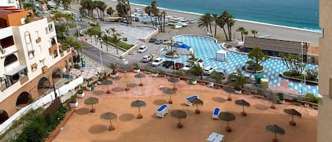 Una località turistica con piscina, spiaggia e vista sull'oceano.