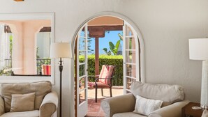 Ein Zimmer mit Blick auf einen Garten, ein Sessel und zwei Sofas.
