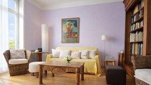A living room with a sofa, two armchairs, a coffee table, a bookshelf, and a painting on the wall. - Charming house near the beach for 6 people (Les Sables-d´Olonne)