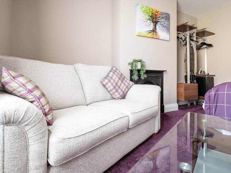 A living room with a sofa, a fireplace, a painting, and a bike rack.