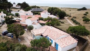 Ein Küstenwohngebiet mit Häusern, freiem Blick auf das Meer und einem Feldweg.