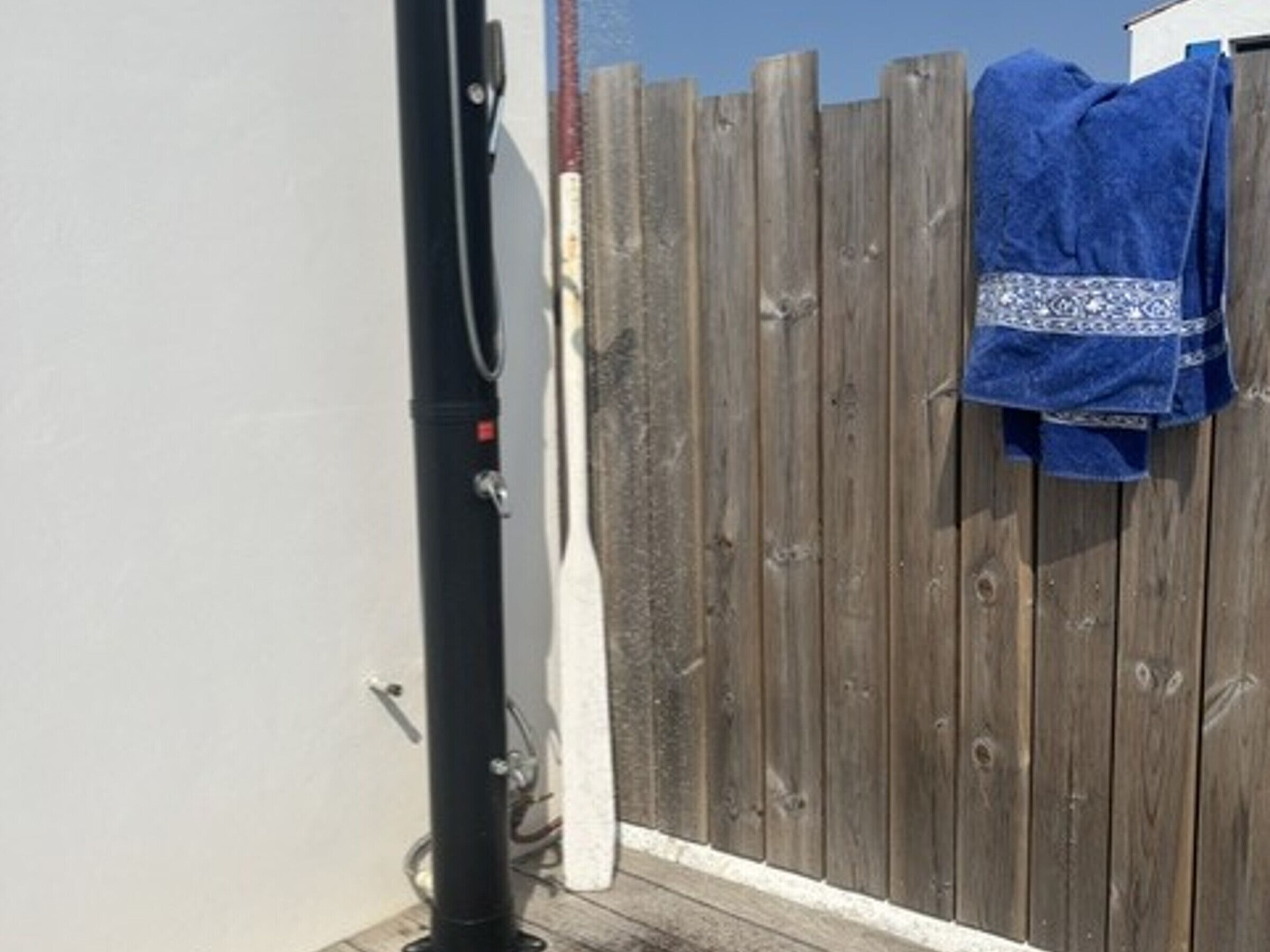 A wooden fence with a towel hanging on it.