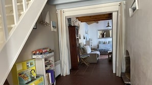 Une pièce avec un escalier, un espace de jeux avec des jouets, un lit et une chaise.