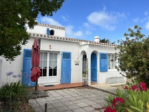 A white building with blue shutters, a small balcony, and a red umbrella. - House near sea and woods - 6 guests (La Guérinière)
