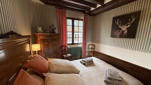 Een kamer met een bed, een stoel, een lamp, een radiator en een raam.