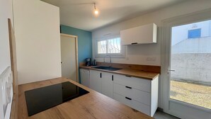 A compact kitchen with a wooden countertop, a sink, and a window. - Charming house near forest - 6 guests (Saint-Jean-de-Monts)