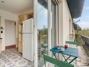 A kitchen with a refrigerator, wooden cabinets, and a tiled floor. - Bright apartment near beach - 6 guests (Biarritz)