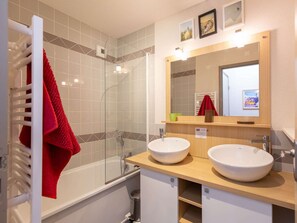 A modern bathroom with two sinks, a glass shower enclosure, and a towel rack with a red towel. - Apartment near village - 10 guests (Barèges)