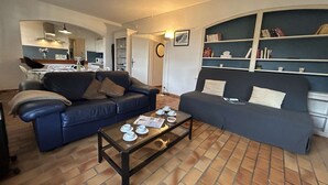 Ett vardagsrum med två soffor, ett soffbord och en bokhylla.