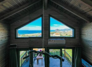 A wooden cabin with a large window and a hanging air conditioner. - Koru Wooden House (Gazipasa)