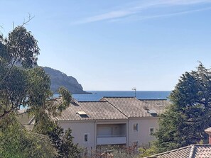Una zona residencial costera con casas de techo de tejas y una vista despejada del mar.