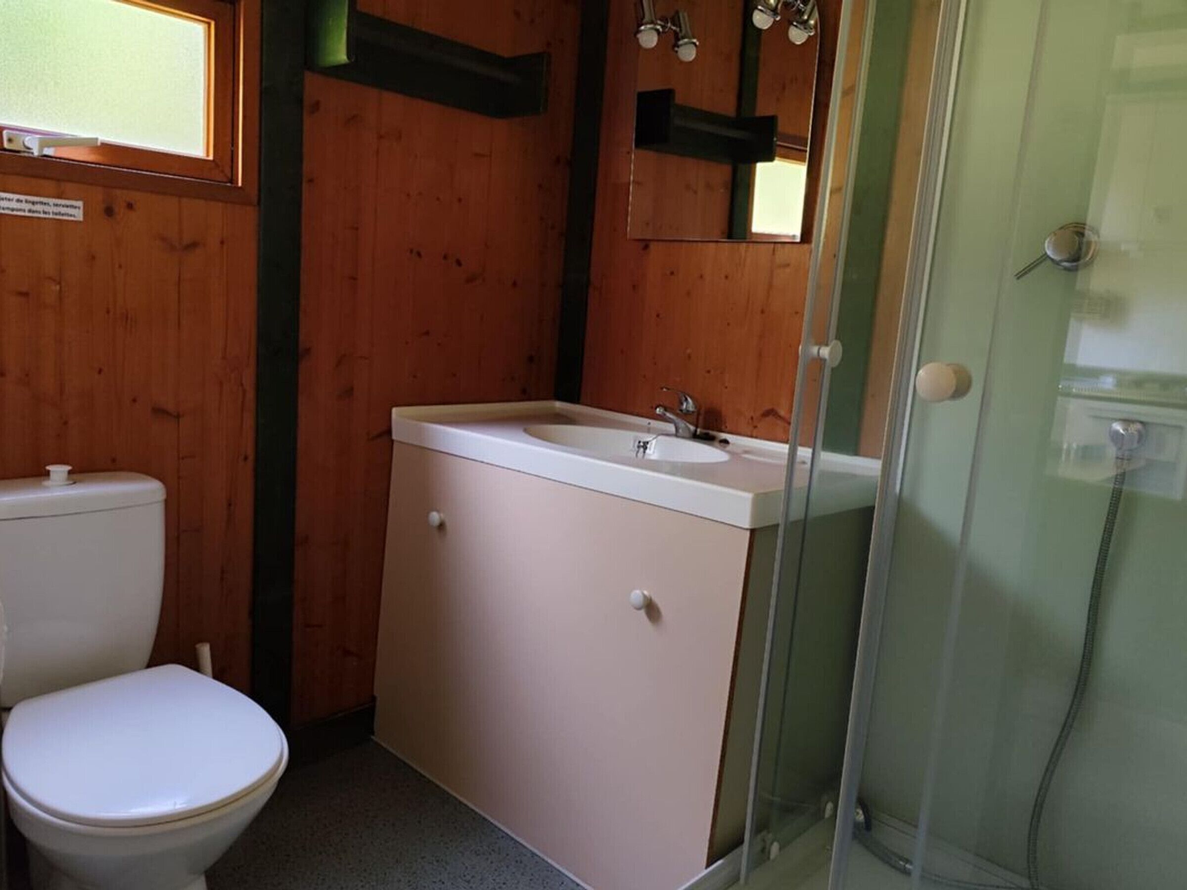 A bathroom with a toilet, sink, and shower.
