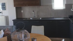 Eine moderne Küche mit dunklen Schränken, einem Edelstahl-Spülbecken und einem Fenster über der Arbeitsplatte.