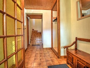A wooden interior hallway with a tiled floor, a wooden bench, and a staircase leading to another room. - Charming chalet near shuttles - 14 guests (Morzine)