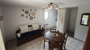 Ein gemütlicher Wohnraum mit Sofa, Esstisch und verschiedenen Wanddekorationen.