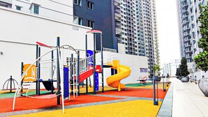 Un'area giochi con scivolo, strutture per arrampicata e una zona colorata di rosso e giallo.