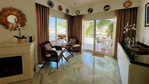 A spacious living area with a fireplace, dining table, and chairs, a balcony with a view, and decorative plates on the wall. - R1387 Casa Udo by CG Nerja Rentals (Nerja)