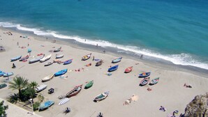 A beach with numerous boats parked on the sand and a clear view of the ocean. - R1387 Casa Udo by CG Nerja Rentals (Nerja)