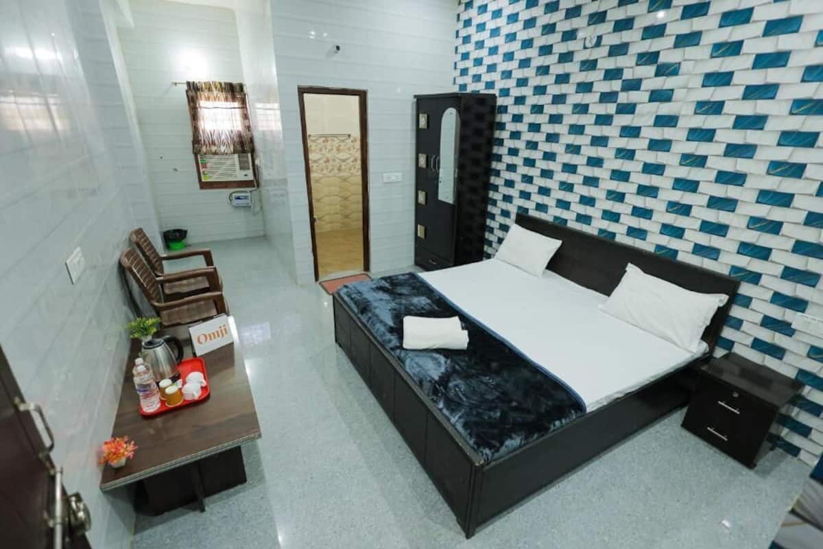 A hotel room with a bed, bedside table, and a wardrobe.