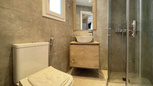 Une salle de bain moderne équipée de toilettes, d’un lavabo et d’une douche.