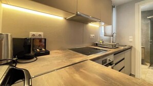 Une cuisine moderne équipée d’une cuisinière intégrée, d’une machine à café et d’un four à micro-ondes.