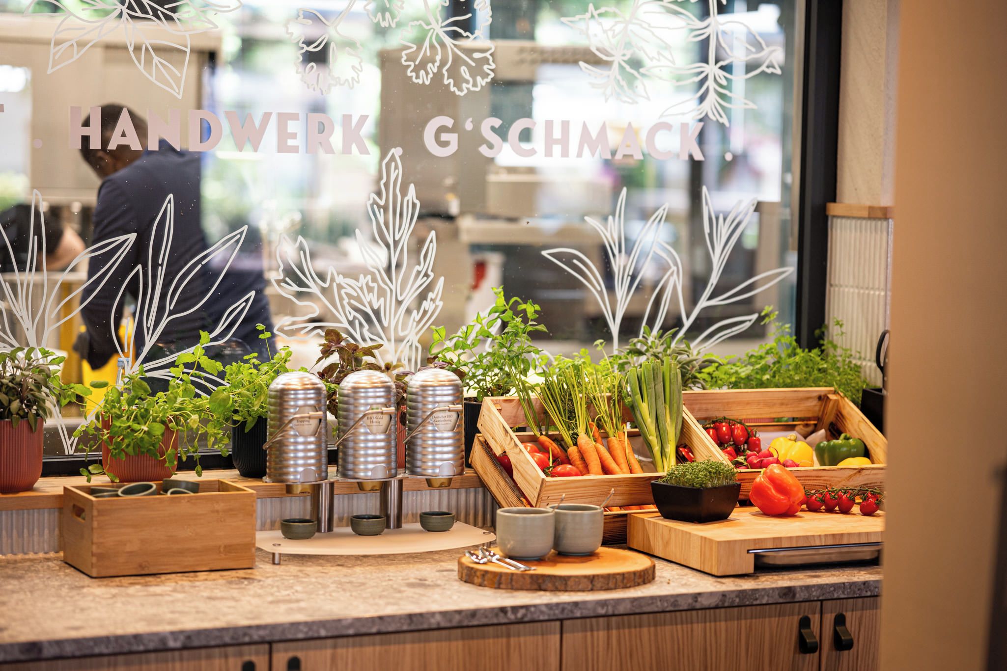 Uma bancada de cozinha com diversas plantas, vegetais e utensílios.