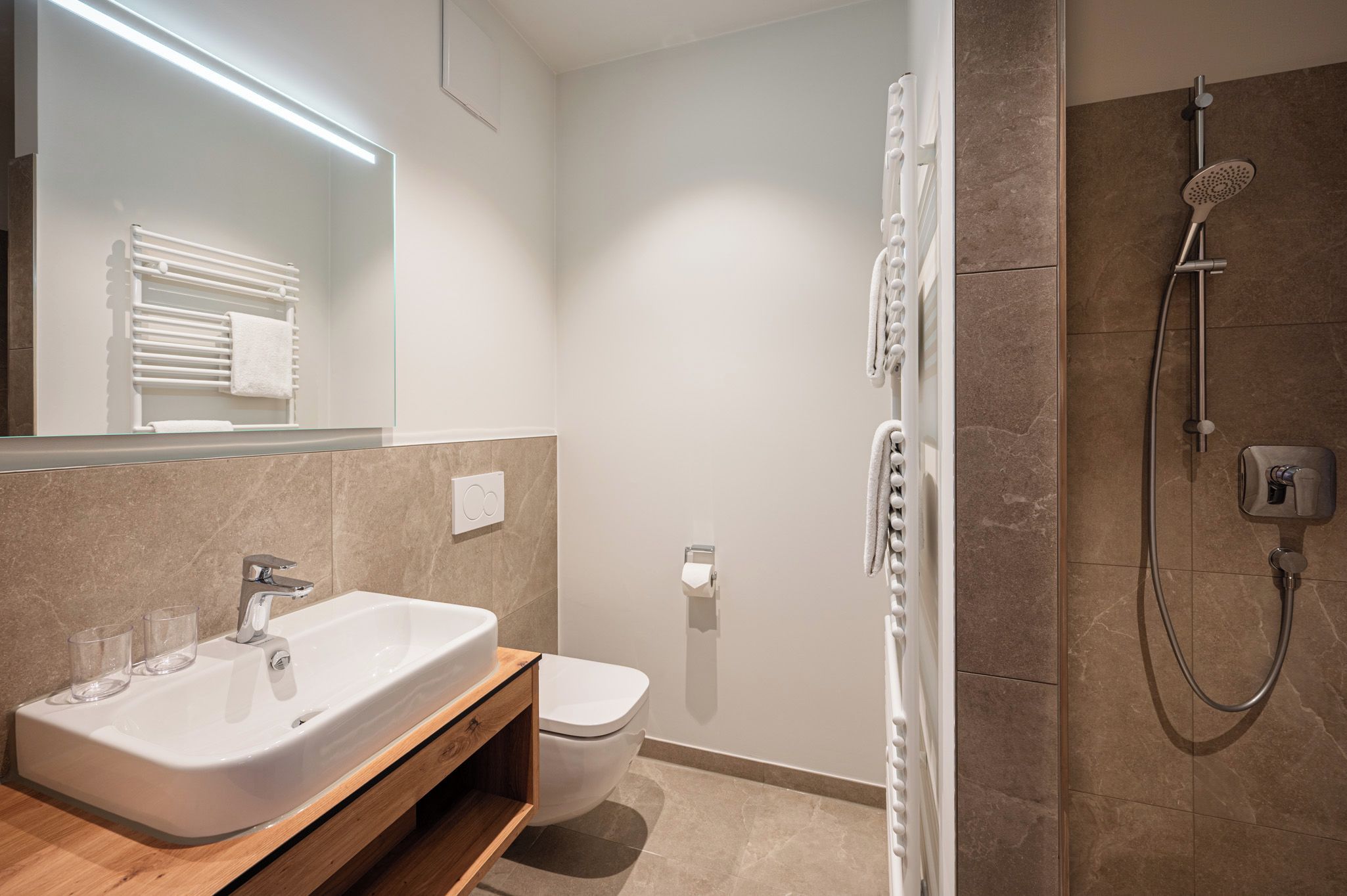 Un baño moderno con una bañera independiente, inodoro y zona de ducha.