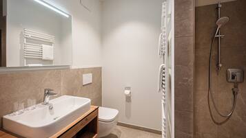 Un baño moderno con una bañera independiente, inodoro y zona de ducha.
