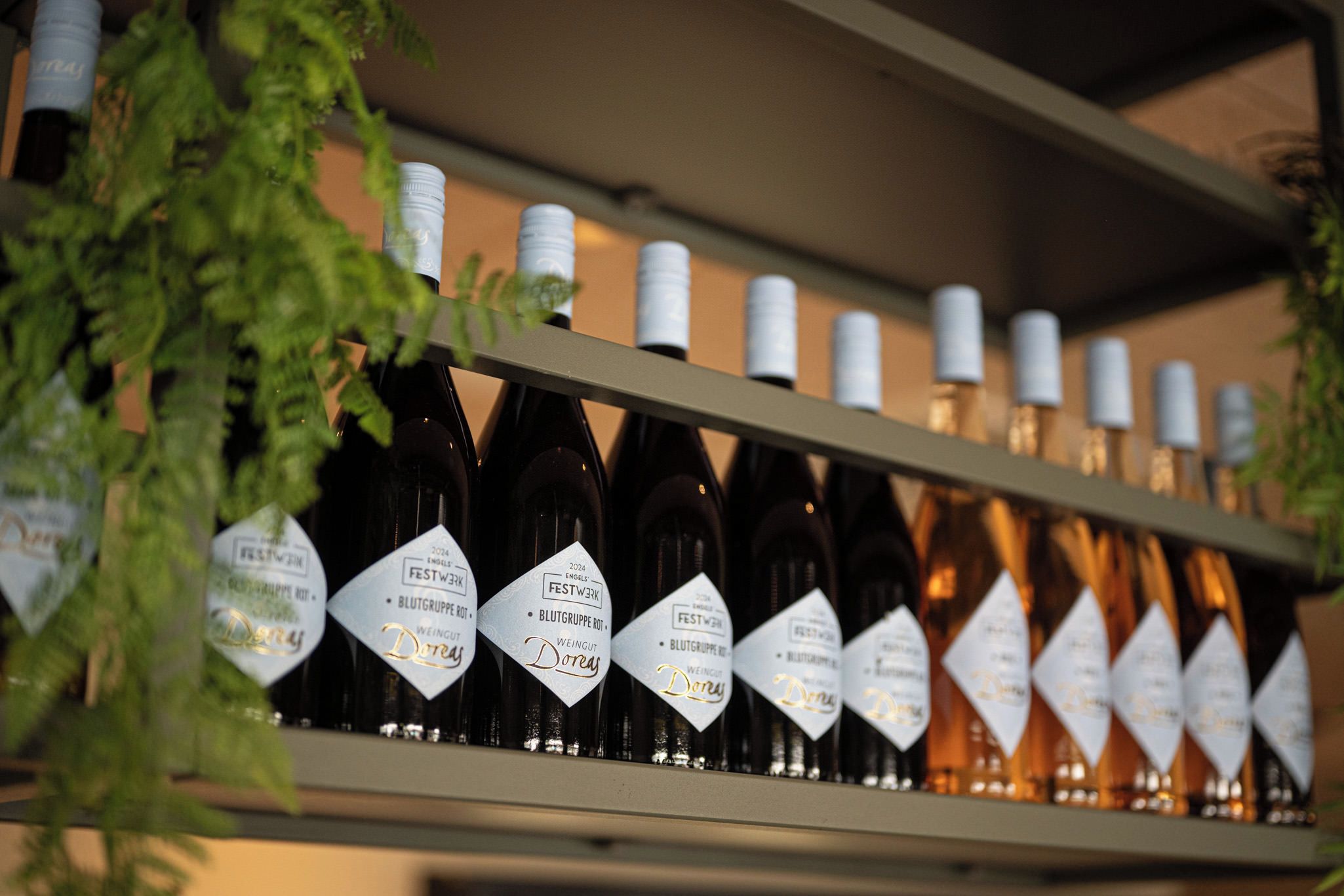 Une étagère remplie de bouteilles de vin, chacune munie d’une étiquette blanche.