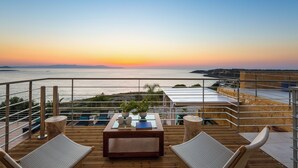 A terrace with a wooden table, two chairs, and potted plants. - Villas Maya 3-bedroom villa in fabulous Chorafakia with private pool (Chorafakia)