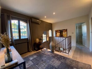 Ein geräumiges Zimmer mit großem Fenster, einer Treppe und Blick ins Freie.