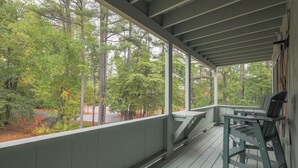 Eine überdachte Veranda mit Blick auf Bäume und eine Straße.