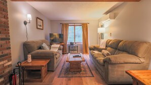 Ein gemütliches Wohnzimmer mit zwei Sofas, einem Couchtisch und einem Fernseher.