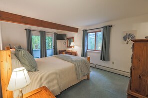Quarto com cama, mesas de cabeceira, abajur, cômoda, janela com cortinas e espelho na parede.