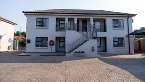 A two-story building with a central staircase, a red mailbox, and a fire hydrant. - Prisatt Boutique Hotel (Lephalale)