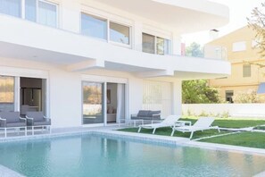 A modern two-story house with a swimming pool, outdoor seating, and a well-maintained lawn. - Athenean Pool Heaven (ELLINIKO)