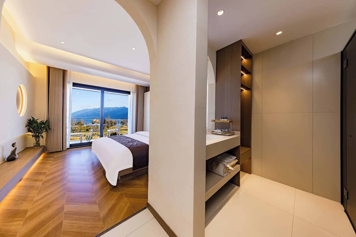Une chambre d’hôtel moderne avec un grand lit, une vue sur la ville et un balcon.