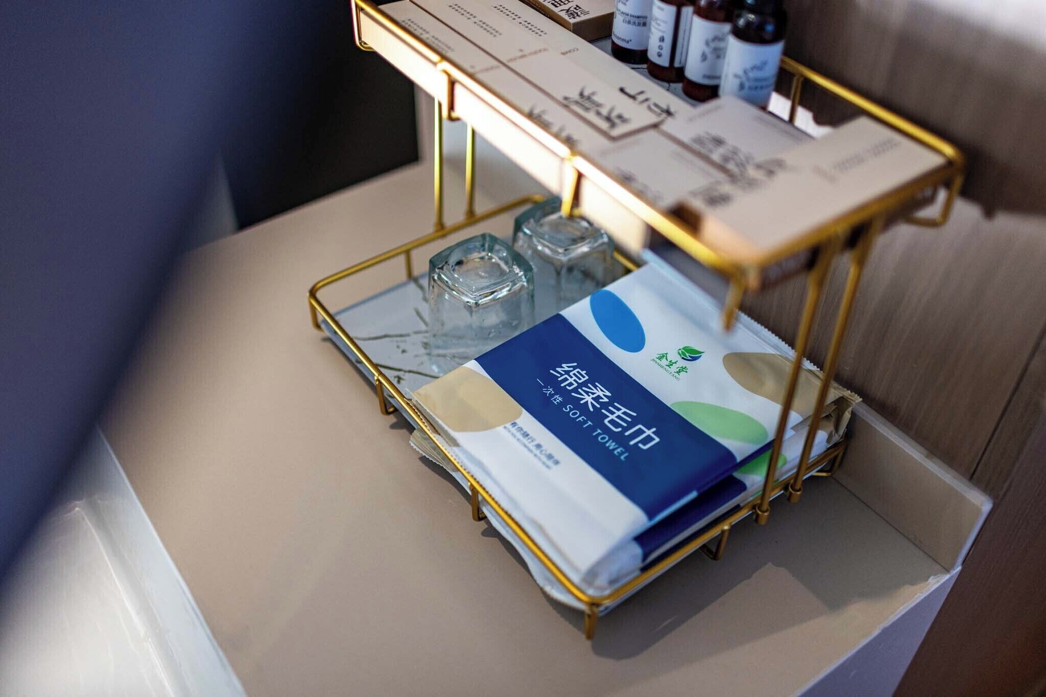 Habitación de hotel con minibar, una botella de agua y pañuelos de papel.