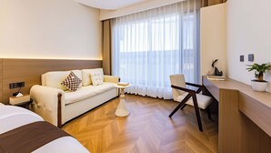 A hotel room with a bed, a sofa, a desk, a chair, and a large window with curtains. - Dali Haohai Yueju Seascape Guest House (Dali)