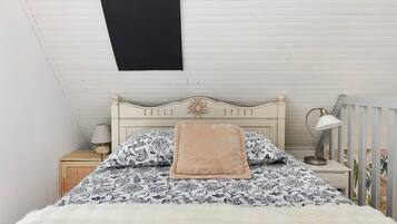 A bedroom with a bed, a nightstand, a lamp, and a ceiling fan.
