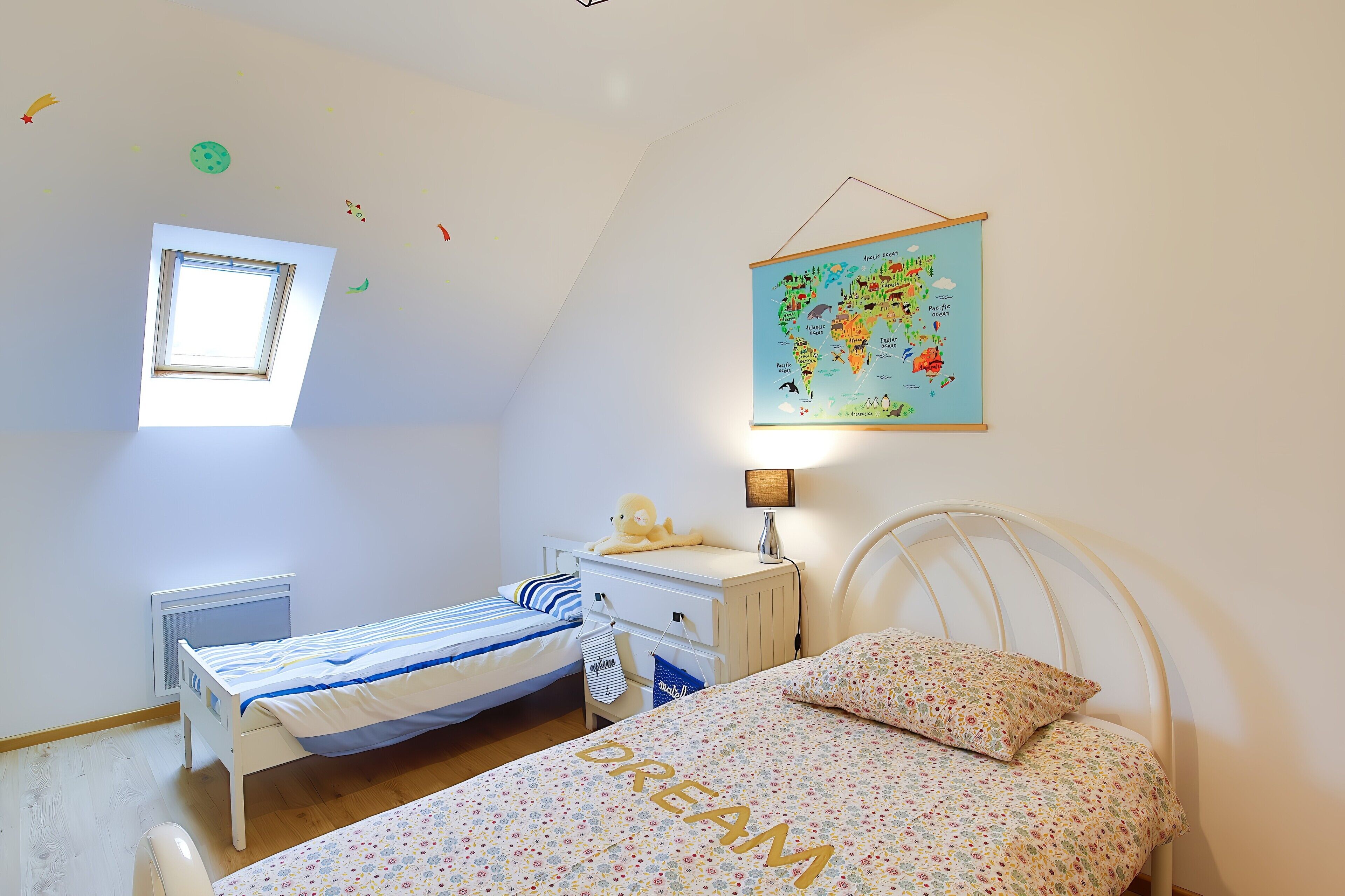 Un dormitorio infantil con literas, un escritorio, un mapa terráqueo y una ventana.