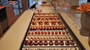 A bakery display with various pastries and a coffee machine. - Marina Suite (Loano)