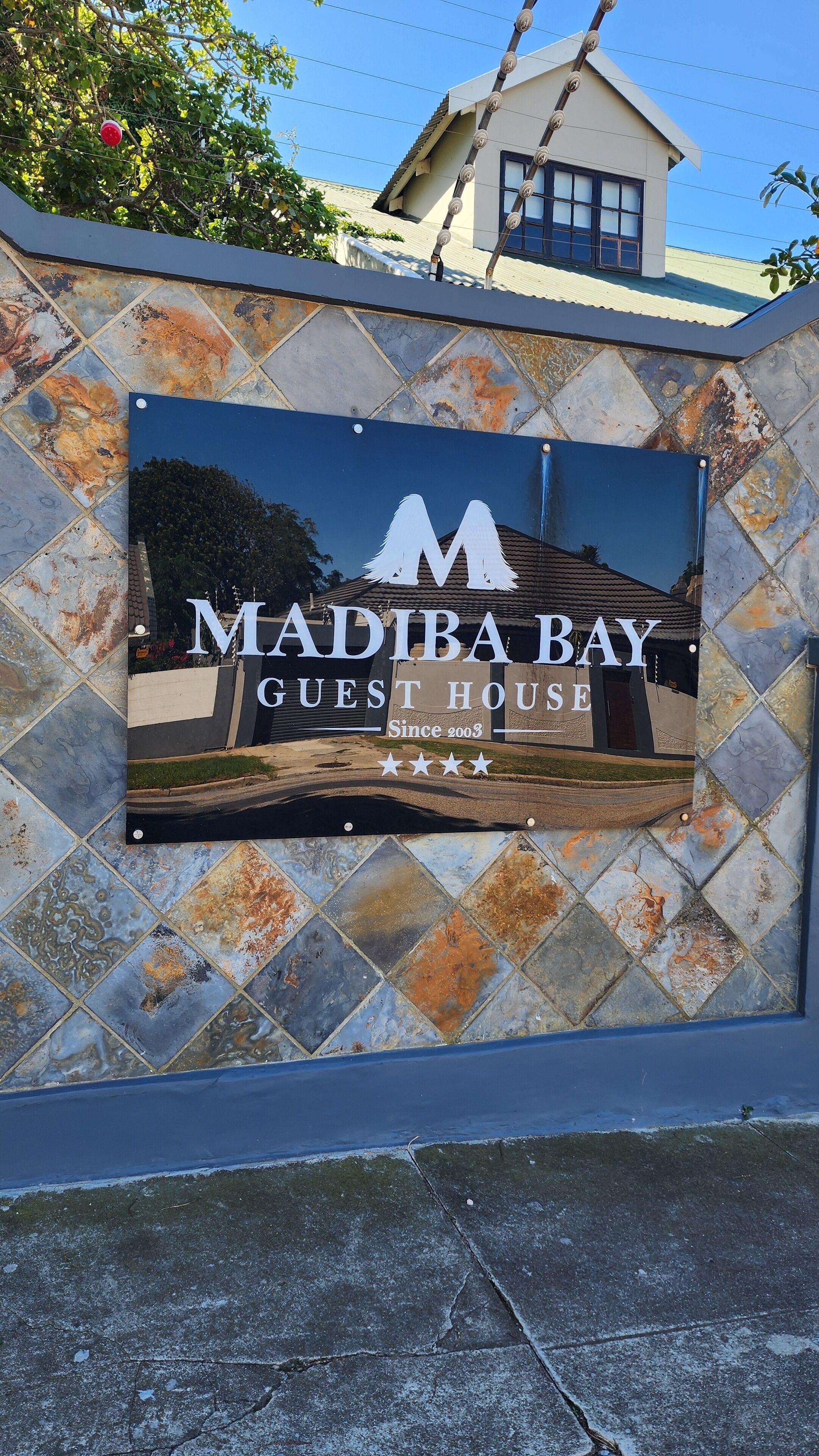 Une enseigne indiquant l’emplacement de la maison d’hôtes Madiba Bay, avec une vue sur la propriété.