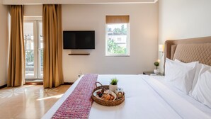 A hotel room with a bed, a TV, a window, and a breakfast tray. - Staymaster Terra Tango 4BR Villa (Calangute)