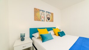 A neatly arranged bedroom with a bed, pillows, a bedside table, and wall art. - Lily Suite (Massa Lubrense)
