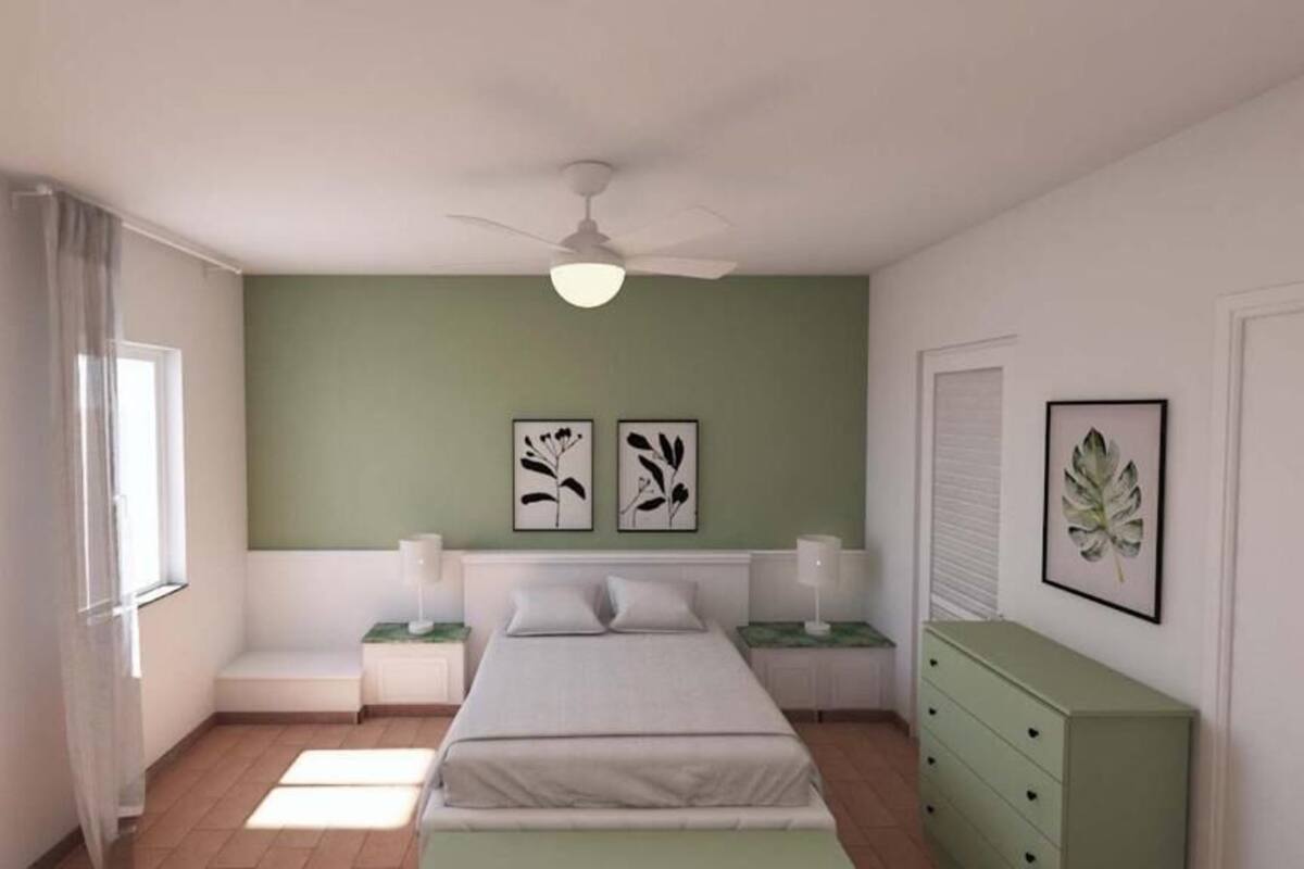 A bedroom with a bed, two bedside tables, a nightstand, a ceiling fan, and a dresser.