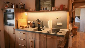 Een keuken met houten kastjes, een dubbele spoelbak en diverse keukenapparaten.