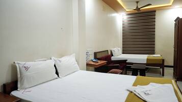 Una habitación de hotel con cama, mesita de noche, escritorio, silla y armario.
